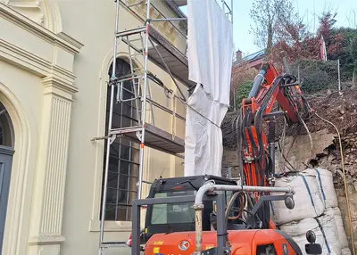 The bulk bags installed as an emergency stabilization measure between the wall and the synagogue are preventing further deterioration.